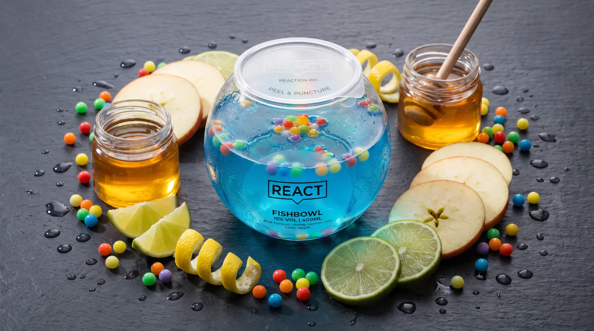 REACT Fishbowl surrounded by apple, lime, citrus peel, honey and multicoloured pearls